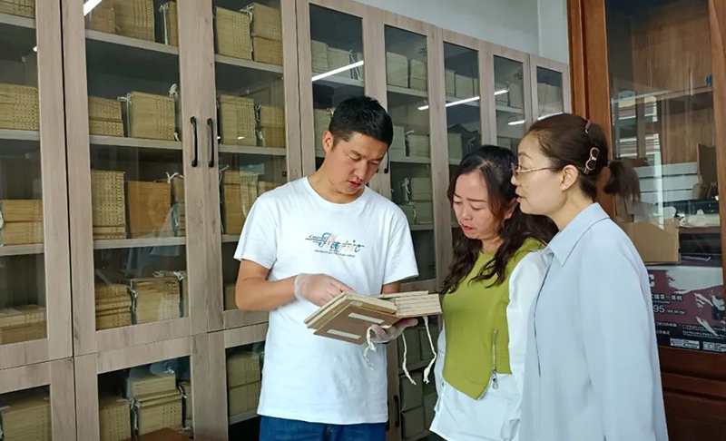 張旻（左）在大通縣圖書(shū)館了解、翻閱清代印制的經(jīng)史子集典籍