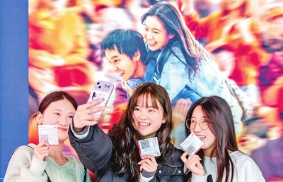 2月18日，觀眾在貴州省黔西市一家影院的電影海報前留影。 新華社發(fā)
