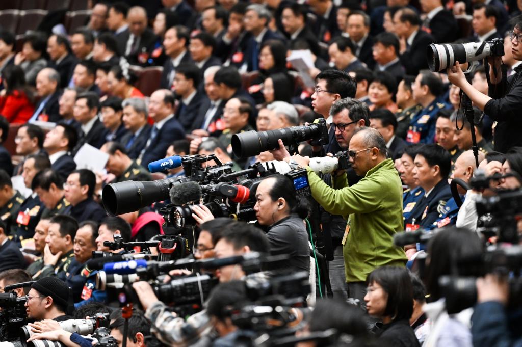 3月8日，十四屆全國人大二次會議在北京人民大會堂舉行第二次全體會議。這是記者在會議現(xiàn)場采訪。新華社記者 牟宇 攝