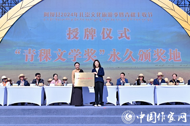 陳亞軍主編代表《民族文學(xué)》向阿壩縣授牌，紅梅部長(zhǎng)接牌。