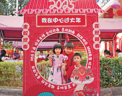 老撾民眾在“歡樂春節(jié)”廟會現(xiàn)場設(shè)立的新春祈福打卡點拍照。  坎帕頌攝