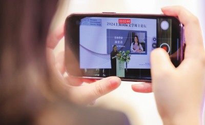 在2024上海國際文學(xué)周主論壇的會場，一位觀眾在用手機錄制日本推理小說家湊佳苗的發(fā)言。上海國際文學(xué)周供圖